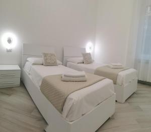 米兰Residenze Niguarda E的卧室设有2张床和白色的墙壁。