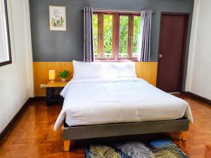 清迈Doodle Lodge Chiang Mai的一间卧室设有一张大床和窗户