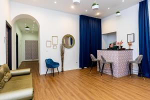 布达佩斯Adagio Downtown Rooms的客厅配有桌子和蓝色椅子