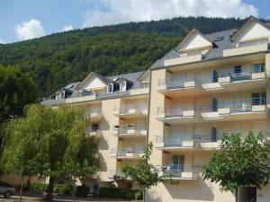 巴涅尔-德吕雄Appartement Bagnères-de-Luchon, 4 pièces, 6 personnes - FR-1-313-140的一座大公寓楼,后面是一座山