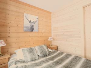 葱仁谷Appartement Val Thorens, 3 pièces, 5 personnes - FR-1-637-3的卧室配有一张床和鹿的照片