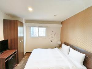 台南信然文旅-首學 寵物友善預訂前務必事先詢問的卧室设有一张白色大床和一扇窗户。