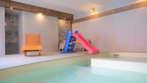 迪耶河畔弗拉诺夫Babyhotel Karolínka, wellness的一座房子,设有一座带滑梯和椅子的游泳池