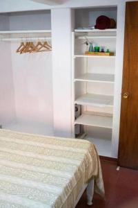 皮里亚波利斯Casa para 4 pers. con entrada de auto y parrillero的一间卧室配有一张床和一个开放式衣柜