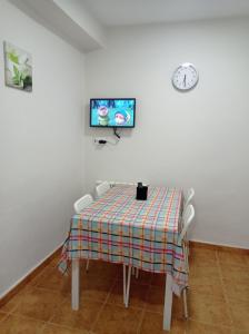 奥伦塞PISO BENITO的一张桌子和椅子,白色的墙上配有电视