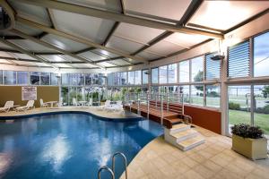 班伯里Bunbury Hotel Koombana Bay的一座带大堂的大型建筑中的游泳池