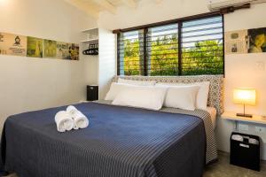 喀巴里特El Encuentro Surf Lodge的一间卧室配有一张床,上面有两条毛巾