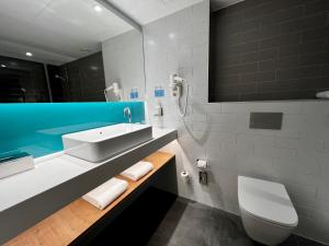 马德里Holiday Inn Express - Madrid - Airport, an IHG Hotel的一间带水槽、卫生间和镜子的浴室