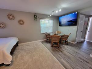 萨拉索塔Walk To Siesta Beach, Restaurants, Shopping & More!的卧室配有桌子和墙上的电视。