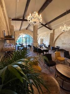 圣吉尔Domaine du Prieuré d'Estagel的一间带桌椅和吊灯的餐厅