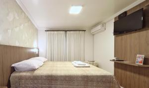 特雷齐蒂利亚斯Hospedaria Hartmann Haus的配有一张床和一台平面电视的酒店客房