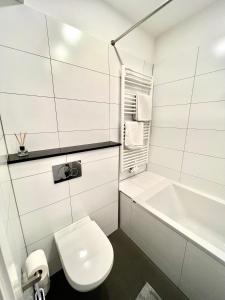 杜塞尔多夫Cityapartments Düsseldorf - Stresemannstraße的白色的浴室设有卫生间和浴缸。
