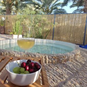 H̱aẕevaאתיטיוד בערבה attitude at the arava的游泳池旁的水果碗和葡萄酒