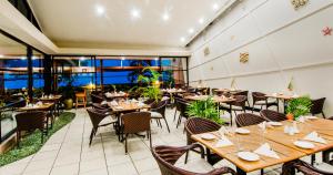 劳托卡陶娜水蓝酒店的餐厅设有木桌、椅子和窗户。