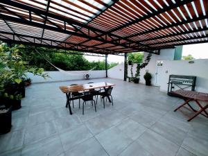 圣拉斐尔La Terraza Apartment: lujoso, amplio y ubicado en microcentro.的凉亭下带桌椅的天井