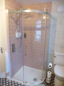 科尔温湾Delfryn Holiday Cottage的浴室里设有玻璃门淋浴