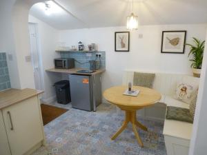 科尔温湾Delfryn Holiday Cottage的一间带桌子和小桌子的厨房和一间房间