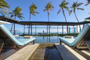 苏梅岛The Sea Koh Samui Resort and Residences by Tolani - SHA Extra Plus的一个带2把躺椅的游泳池,棕榈树