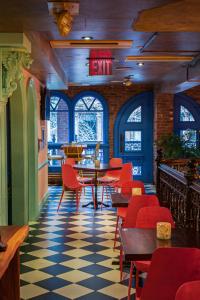 纽约Hotel Scherman的一间餐厅,房间内设有红色的椅子和桌子