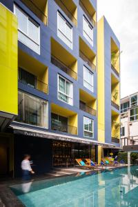 曼谷LiT BANGKOK Residence的一座建筑前面设有游泳池