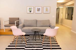 圣保罗360 Av Ipiranga的客厅配有沙发和2把粉红色的椅子
