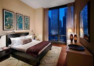 纽约Lovely 3 Bedroom Condo near Central Park的一间卧室设有一张大床和一个大窗户