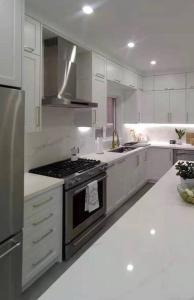 纽约Lovely 3 Bedroom Condo near Central Park的厨房配有白色橱柜和炉灶烤箱。