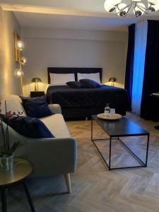 埃尔斯洛艾尔斯鲁城堡餐厅酒店的一间卧室配有一张床、一张沙发和一张桌子