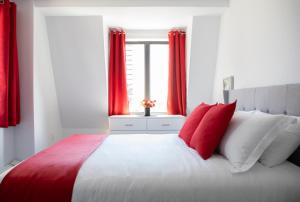 哈利法克斯Cameo Hotel and Suites的一间卧室配有一张带红色窗帘的大床