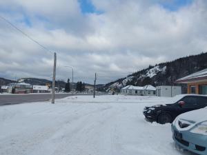 SchreiberSunset Motel的一条雪覆盖的街道上停有汽车