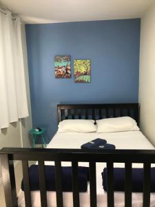 里约热内卢More Só的一间卧室配有一张蓝色墙壁的床
