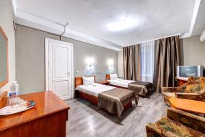 基辅豪罗斯维斯基酒店的酒店客房,设有两张床和一张沙发