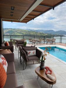 卡皮托利乌Vista do Lago Hotel的庭院设有游泳池和桌椅