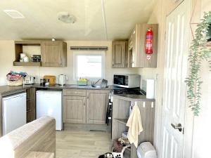 纽顿Trecco Bay Porthcawl Caravan 8 berth PALMS 4的一间带木制橱柜和炉灶的小厨房