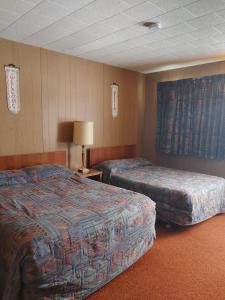 SchreiberSunset Motel的酒店客房,设有两张床和一盏灯