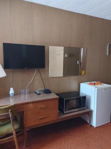 SchreiberSunset Motel的客房设有带微波炉和冰箱的书桌。