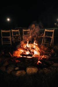 ZatoryDrwalski Zakątek的夜间火坑周围摆放着三把椅子