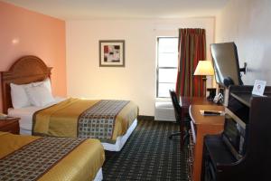 威奇托福尔斯威奇托福尔斯行政汽车旅馆的酒店客房设有两张床、一张桌子和一台电视。