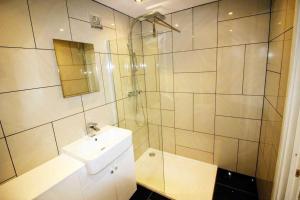 布里克瑟姆Boutique Apartment Brixham的白色的浴室设有水槽和淋浴。