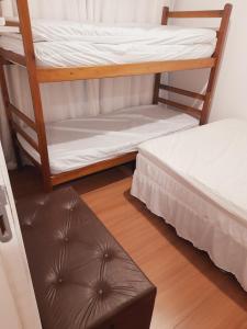 圣塞巴斯蒂安Lindo Flat em Maresias的铺有木地板的客房内设有两张双层床。