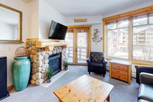 铜山Tucker Mountain Lodge 307a的客厅设有石制壁炉和桌子。