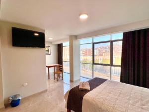 La ApachetaHOTEL DORADO AREQUIPA的酒店客房设有一张床和一个大窗户