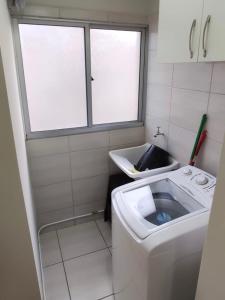 波苏斯-迪卡尔达斯Aconchego Poços de Caldas的一间带洗衣机和窗户的小浴室