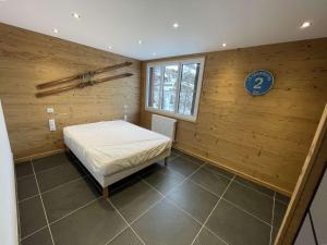 瓦尔Appartement Vars, 3 pièces, 8 personnes - FR-1-330B-146的卧室配有木墙内的一张床