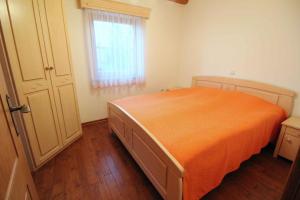 ČrnomeljHoliday home in Crnomelj - Kranjska Krain 35279的一间卧室配有橙色的床和窗户。