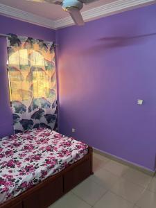 瓦加杜古Ouedraogo Property Management的一间卧室配有一张床和紫色的墙壁