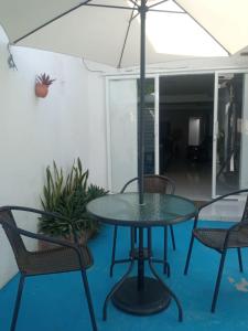 托卢Hostal Girasoles Tolu的庭院内桌椅和遮阳伞