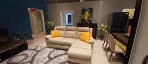 MahinaFENUA ORA的客厅配有白色沙发和黄色枕头。