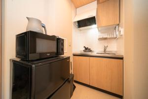 大阪WELLSTAY Shinsekai Wakyo的厨房配有冰箱上方的微波炉