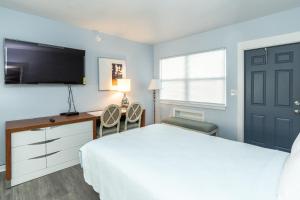 克利尔沃特Echo Sails Motel的一间卧室配有一张床、一张书桌和一台电视。